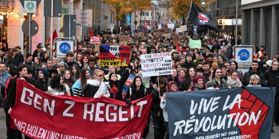 Teilnehmer einer Demonstration unter dem Motto «Gen Z regelt» gehen hinter Transparenten «Gen Z regelt» und «Vive La Revolution». Foto: Uli Deck/dpa