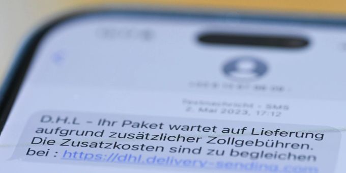 Auf einem Smartphone ist eine Betrugs-SMS zu lesen, in der Kriminelle ein Paket ankündigen und dafür Zollgebühren einfordern. Auf einem Smartphone ist eine Betrugs-SMS zu lesen, in der Kriminelle ein Paket ankündigen und dafür Zollgebühren einfordern.