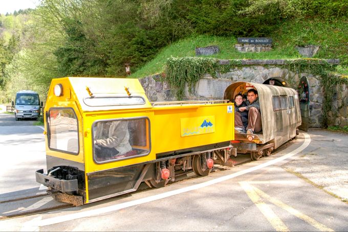 Die Minigrubenbahn bringt Besucher in den Berg. Bahn gelb Schiene Bergwerk