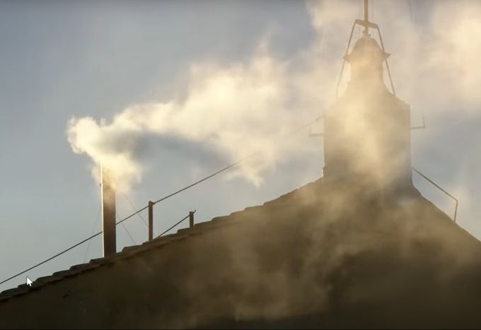 Weisser Rauch strömt aus dem Kamin. Das Zeichen, dass ein neuer Papst feststeht. Kamin