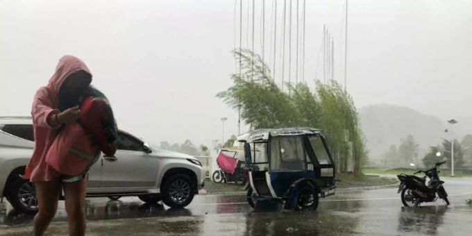 Ein Mann sucht Unterschlupf vor den heftigen Regenfällen taifun rai