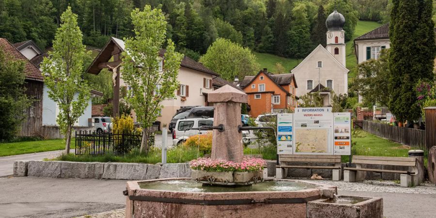 Dorfbrunnen in Vilters-Wangs mit Blick auf die Kirche.