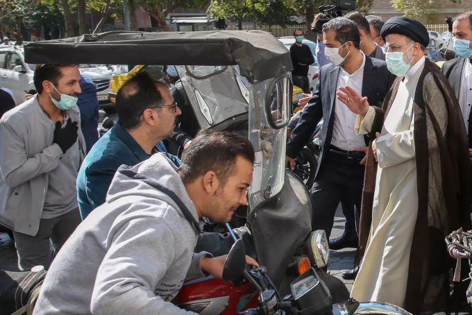 Ebrahim Raisi (r), Präsident des Iran, winkt, als er eine Tankstelle in Teheran nach dem Cyberangriff besichtigt. Iran