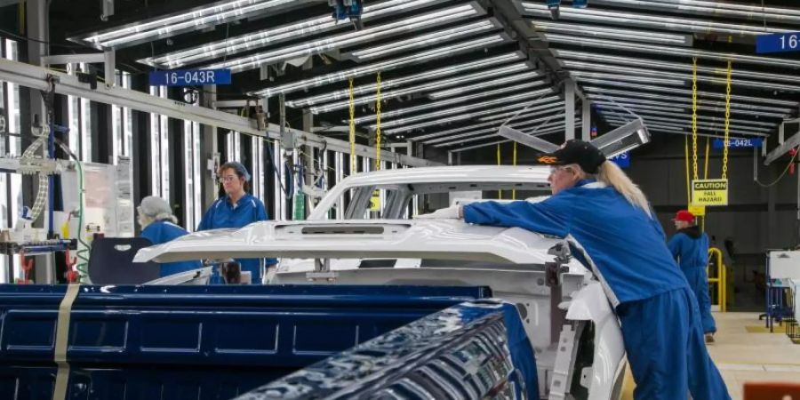 Arbeiter führen in einer Lackiererei von General Motors in Flint eine Endkontrolle durch. Der grösste US-Autobauer ist im vergangenen Quartal besonders hart von den branchenweiten Chip-Lieferengpässen getroffen worden. Foto: Ryan Garza, Detroit Free Press/TNS via ZUMA Wire/dpa