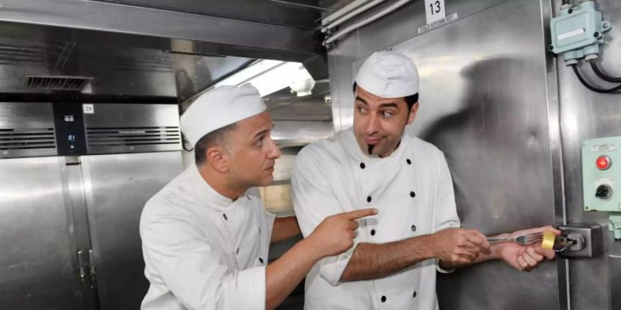 Nachdem Cem (Bülent Ceylan, r) und sein Bruder Hassan Meierbrink (Özcan Cosar) als Stand-up-Comedians gescheitert sind, versuchen sie sich als Küchenhilfen an Bord des «Traumschiffs». Foto: Dirk Bartling/ZDF/dpa