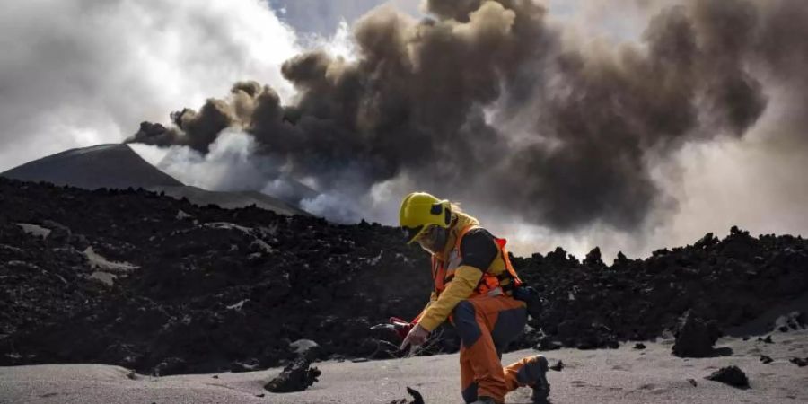 Ein Wissenschaftler des IGME-CSIC (Geologisches und Bergbauinstitut Spaniens des Spanischen Nationalen Forschungsrats) misst die Temperatur von Lava in der Nähe eines Vulkans auf der Kanarischen Insel La Palma. Foto: Taner Orribo/AP/dpa