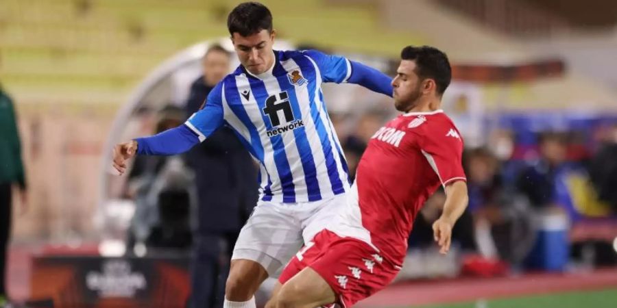 Monacos Kevin Volland (r) im Zweikampf mit Martin Zubimendi von Real Sociedad. Foto: Jonathan Moscrop/CSM via ZUMA Wire/dpa