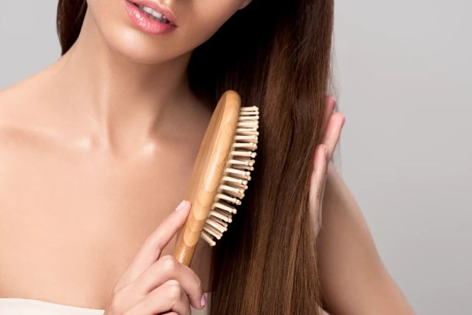 Frau bürstet sich die Haare.
