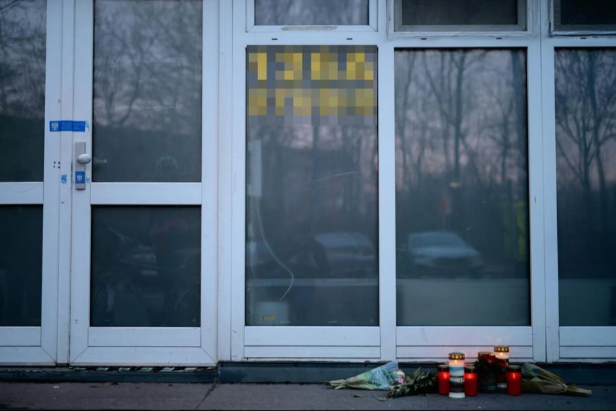 Menschen haben vor dem Erotikstudio Blumen und Kerzen niedergelegt.