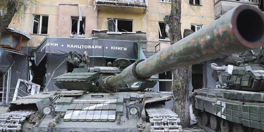 Panzer der Miliz der Volksrepublik Donezk stehen neben einem beschädigten Wohnhaus in Mariupol, einem Gebiet unter der Regierung der Volksrepublik Donezk im Osten der Ukraine. Foto: Alexei Alexandrov/AP/dpa