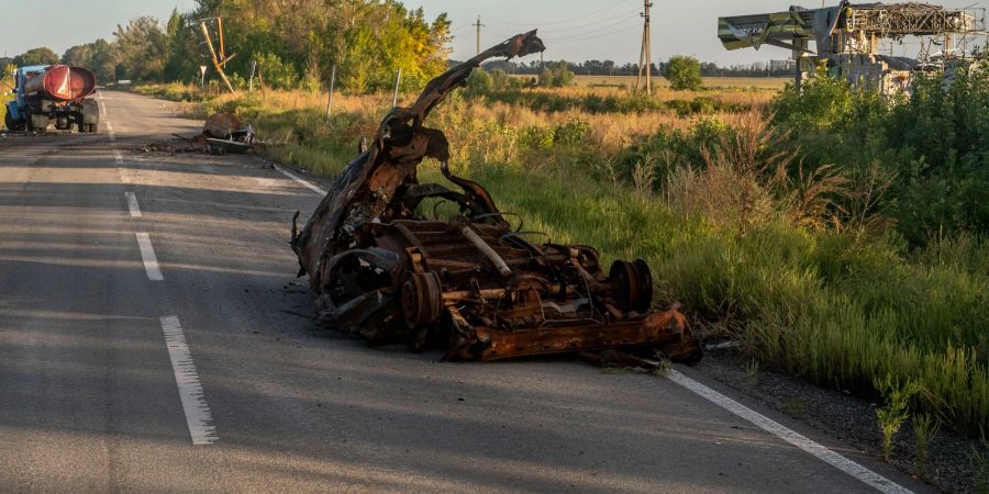 Zerstörte Fahrzeuge stehen auf einer Strasse in der Region Charkiw.