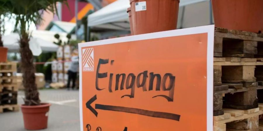 Ein Schild mit der Aufschrift «Eingang - Pro Person 1 Wagen!» am Eingang eines Baumarkts. Foto: Sven Hoppe/dpa