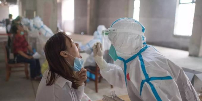 Eine Frau wird in Wuhan von einer Person in Schutzanzug auf das Coronavirus getestet. Wissenschaftler haben in der chinesischen Metropole Freiwilligen den Wirkstoff Ad5-nCoV verabreicht und berichten von ersten Erfolgen. Foto: Xiao Yijiu/XinHua/dpa Eine Frau wird in Wuhan von einer Person in Schutzanzug auf das Coronavirus getestet. Wissenschaftler haben in der chinesischen Metropole Freiwilligen den Wirkstoff Ad5-nCoV verabreicht und berichten von ersten Erfolgen. Foto: Xiao Yijiu/XinHua/dpa