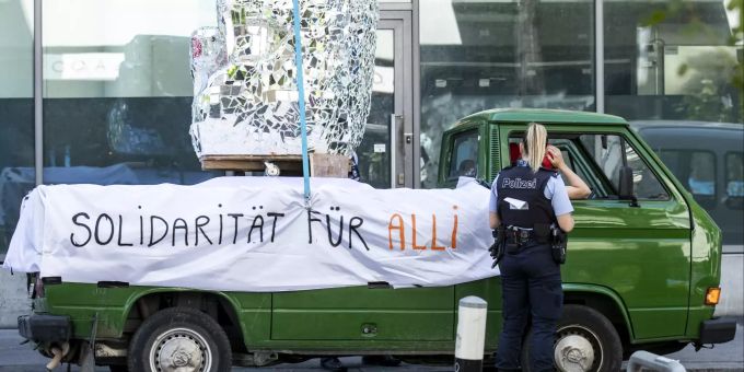 Eine Polizistin spricht mit Demonstranten in einem Fahrzeug, an dem ein Banner mit der Aufschrift "Solidarität für Alli" angebracht ist, während eines Protests für das Leben von Flüchtlingen. Coronavirus - Schweiz
