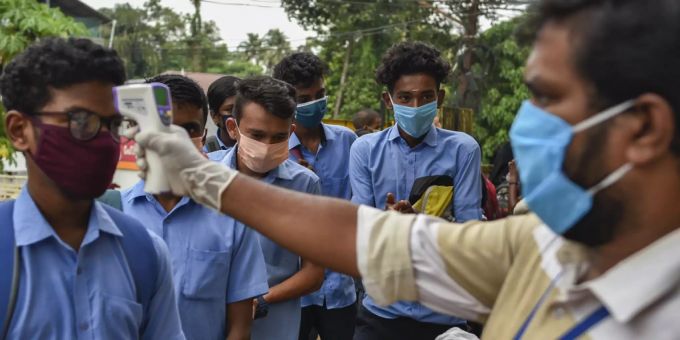 Vor einer indischen Schule wird bei den Schülern die Temperatur gemessen. Coronavirus Indien Prävention