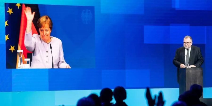 Die per Video live zugeschaltete Bundeskanzlerin Angela Merkel (CDU) verabschiedet sich nach ihrer Reder beim Tag der deutschen Industrie des Bundesverbandes der Deutschen Industrie (BDI). Foto: Bernd von Jutrczenka/dpa