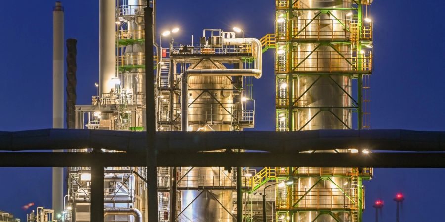 Die Anlagen der Erdölraffinerie auf dem Industriegelände der PCK-Raffinerie GmbH sind abends beleuchtet.