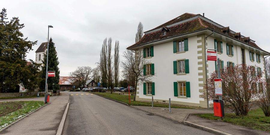 Busshaltestelle Gottstatt an der Gottstattstrasse in Orpund. Rechts die Gemeindeverwaltung und links hinten die reformierte Kirche von Orpund. - Orpund