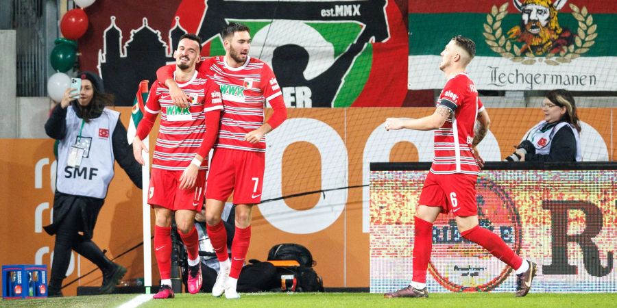 Torschütze Mergim Berisha (l-r), Dion Beljo und Jeffrey Gouweleeuw vom FC Augsburg jubeln über den Treffer zum 1:0 gegen Bayer Leverkusen.