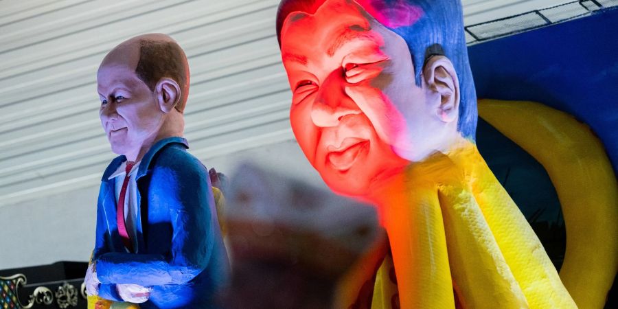 Ein Mottowagen, der Bundeskanzler Olaf Scholz in den Fängen von Chinas Staatschef Xi Jinping zeigt.