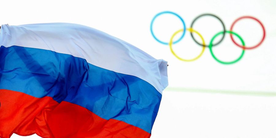 Eine Russlandflagge weht vor den Olympischen Ringen.
