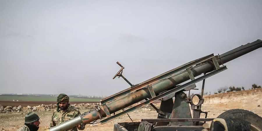 ARCHIV - Von der Türkei unterstützte Soldaten laden einen Raketenwerfer. Die vor fast zehn Jahren in Syrien ausgebrochenen Kämpfe sind 2020 weitgehend abgeklungen. Foto: Anas Alkharboutli/dpa