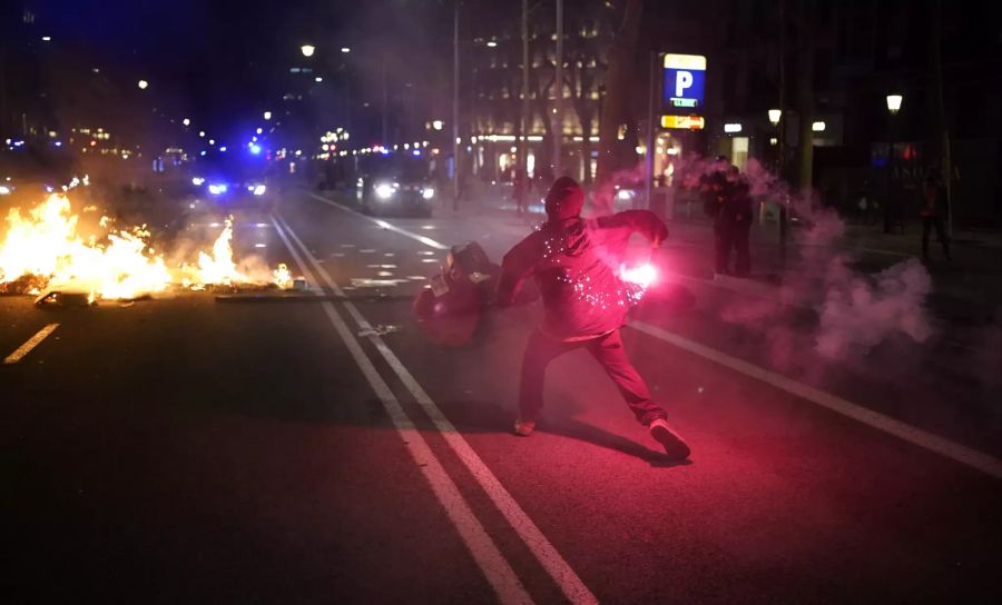 Ein Demonstrant wirft einen Böller in Richtung Polizei.