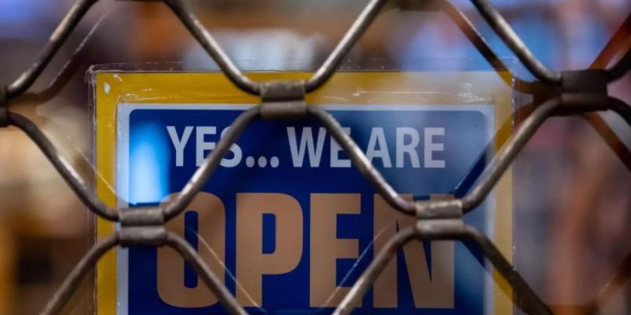 Ein Schild mit der Aufschrift «Yes...we are Open» hängt in einem Münchner Geschäft. Foto: Sven Hoppe/dpa