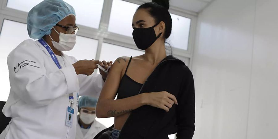 Eine Mitarbeiterin des Gesundheitswesens verabreicht in der Favela Complexo da Mare in Rio de Janeiro eine Dosis des Corona-Impfstoffs von Astrazeneca. Foto: Bruna Prado/AP/dpa