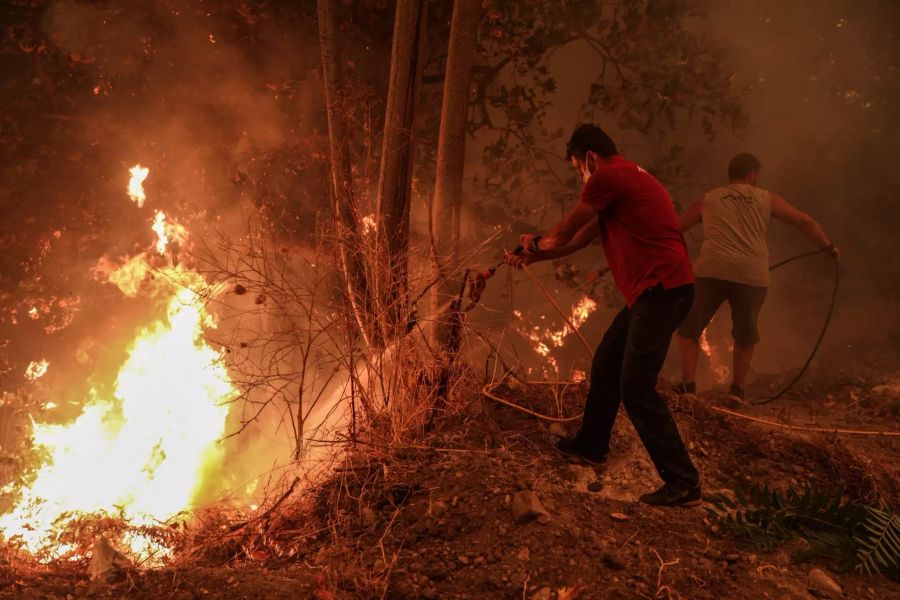 Menschen versuchen, die Flammen während eines Waldbrandes im Dorf Gouves zu löschen.