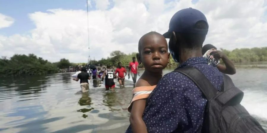 Haitianische Migranten benutzen einen Damm bei Del Rio, Texas, um von Mexiko aus in die Vereinigten Staaten zu gelangen. Foto: Eric Gay/AP/dpa