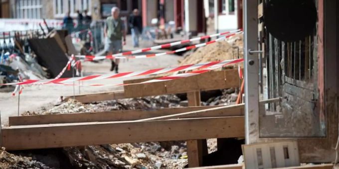 Mit Holzbrücken gelangen Anwohner in der zerstörten Altstadt von Bad Münstereifel in ihre Häuser. Die Flutkatastrophe Mitte Juli hat bislang Versicherungsschäden von rund sieben Milliarden Euro verursacht und damit mehr als bisher erwartet. Foto: Federico Gambarini/dpa Mit Holzbrücken gelangen Anwohner in der zerstörten Altstadt von Bad Münstereifel in ihre Häuser. Die Flutkatastrophe Mitte Juli hat bislang Versicherungsschäden von rund sieben Milliarden Euro verursacht und damit mehr als bisher erwartet. Foto: Federico Gambarini/dpa