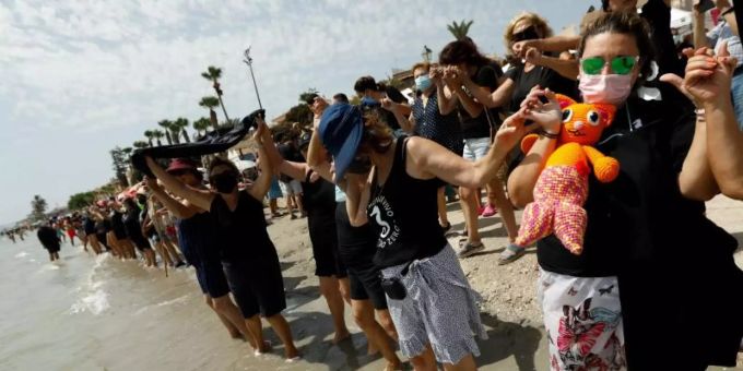 Demonstranten und Demonstrantinnen bilden eine mehr als 73 Kilometer lange Menschenkette am Ufer des Mar Menor. Mar Menor