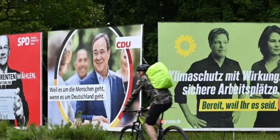 Wahlplakate mit den Spitzenkandidaten von SPD, Union und Grünen in Frankfurt am Main. Olaf Scholz, Armin Laschet und Annalena Baerbock treffen sich am Abend zum TV-Triell. Foto: Arne Dedert/dpa