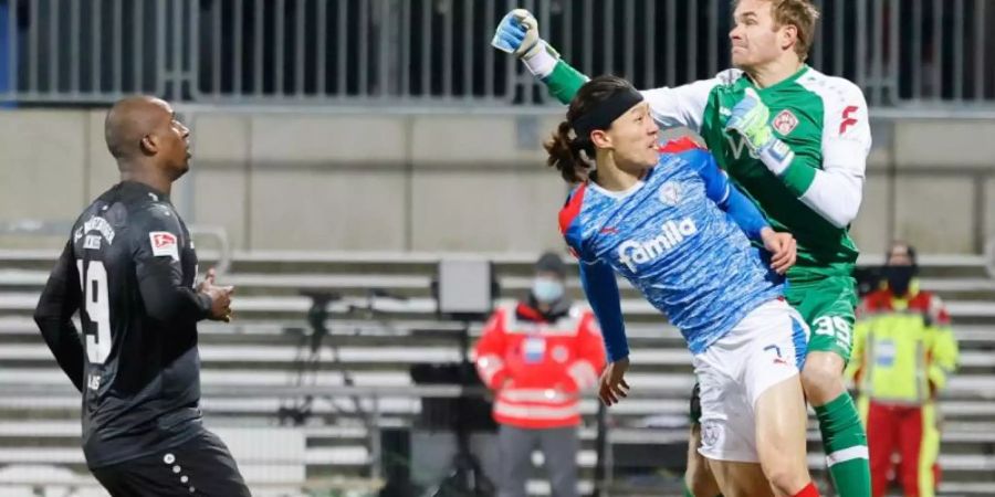 Eine umstrittene Faustabwehr von Würzburg-Keeper Hendrik Bonmann führte letztlich zum Sieg von Holstein Kiel. Foto: Frank Molter/dpa