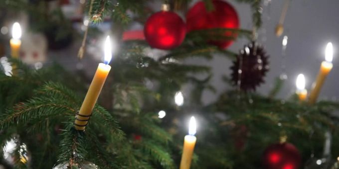 Ein Weihnachtsbaum ist mit brennenden Kerzen geschmückt. kerze feuer othmarsingen maiengrün
