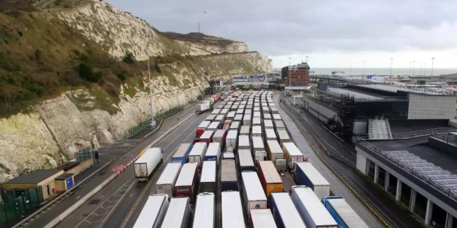 Lastwagen stehen Schlange, um in den Hafen von Dover in Kent einzufahren. An den britischen Häfen stauen sich seit Wochen die Container. Foto: Gareth Fuller/PA Wire/dpa