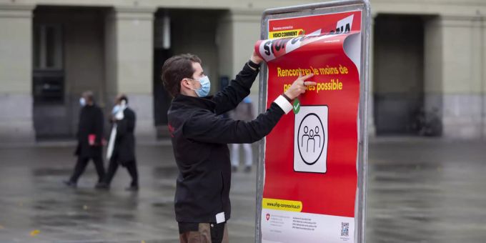 Ein Mitarbeiter des BAG hängt auf dem Bundesplatz in Bern ein neues Corona-Plakat auf. Coronavirus Neuinfektionen Kantone