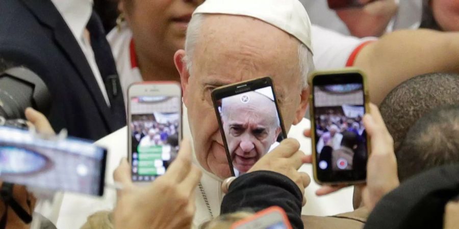 Menschen fotografieren Papst Franziskus.