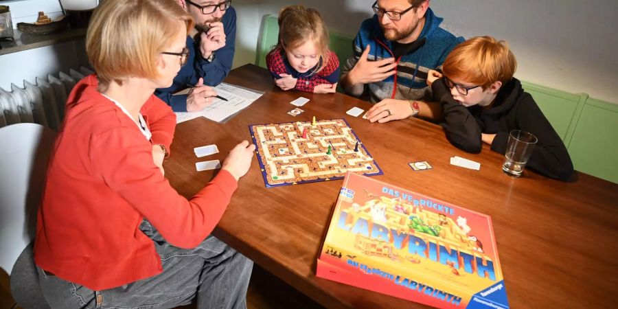 Eine Familie spielt Ravensburger.