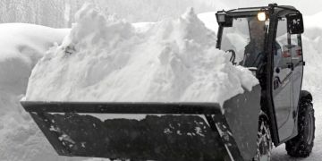 Ein Bagger befreit eine Strasse in Niedertauern vom Schnee.