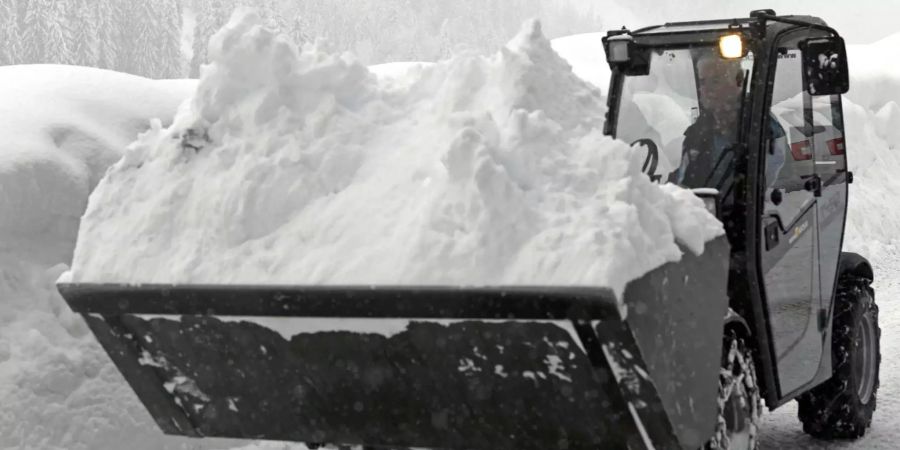 Ein Bagger befreit eine Strasse in Niedertauern vom Schnee.