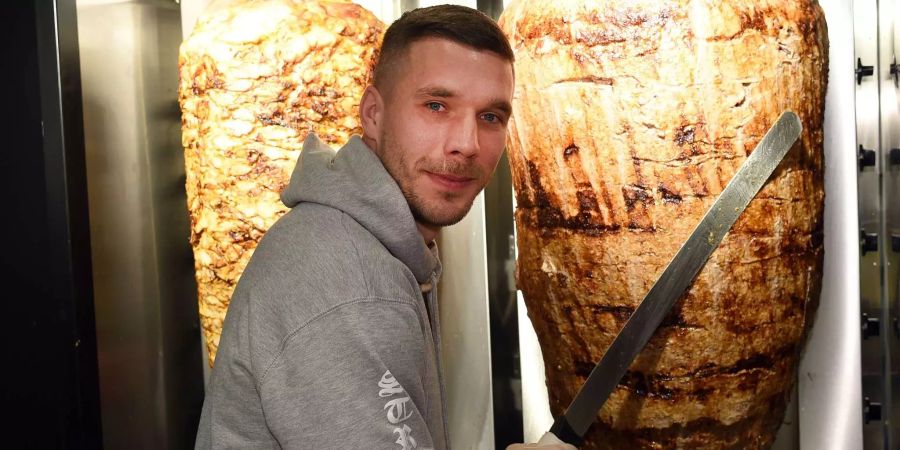 Höchstpersönlich schneidet Lukas Podolski den ersten Fleischspiess seiner neuen Döner-Bude an.