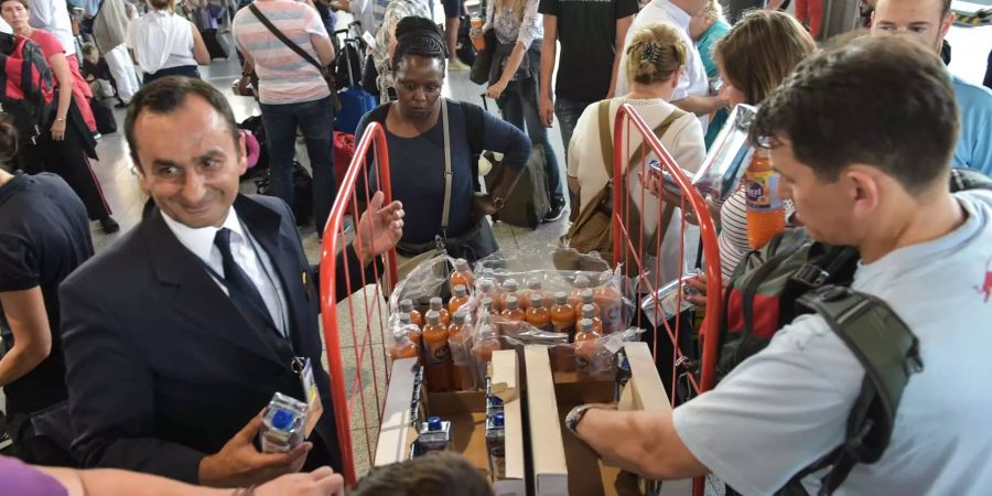 Wartende Passagiere in Halle A im Terminal 1 des Flughafens Frankfurt werden mit Getränken versorgt.
