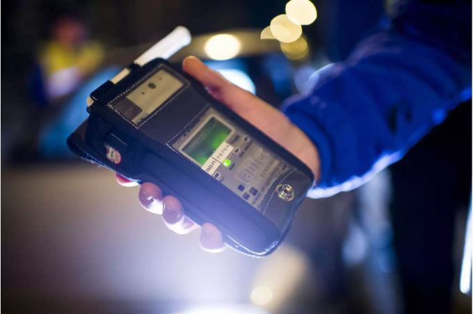 Alkoholtestgerät in der Hand eines Polizisten - Keystone Alkoholtestgerät