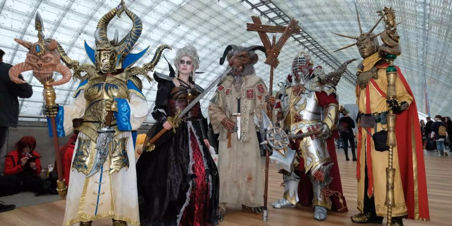 Cosplayer stehen während der Leipziger Buchmesse in der Glashalle des Messegeländes.