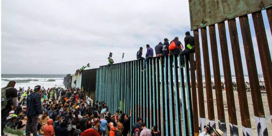 Zentralamerikanische Migranten an der Mauer zur US-Mexiko Grenze.