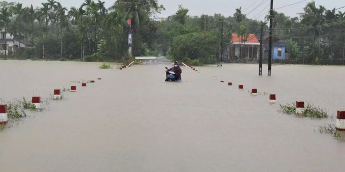 Ein Mann schiebt seinen Motorroller durch hüfthohes Wasser. Starke Regenfälle in den letzten drei Tagen führten zu schweren Überschwemmungen in der zentralen Region Vietnams. Hochwasser in Vietnam