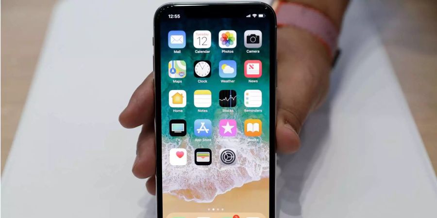 Ein Mann hält im Showroom des Apple-Campus in Cupertino, Kalifornien (US) das iPhone X in der Hand.