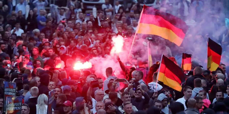 Demonstranten der rechten Szene zünden bei Aufmärschen in Chemnitz (D) Pyrotechnik und schwenken Deutschlandfahnen.